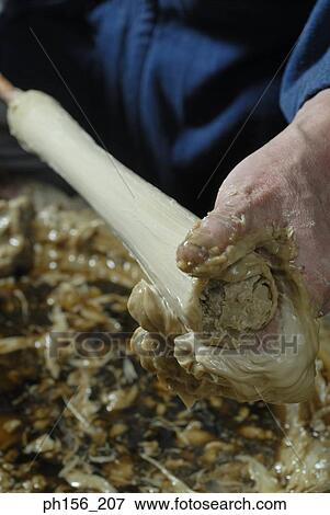 Stock Photo - Close-up of a person's hand making a candle. Fotosearch