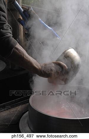 Stock Photo - Close-up of a person's hand mixing dye in a container of hot water. Fotosearch