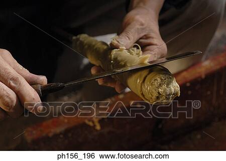 Stock Photograph - Close-up of a person's hand peeling a candle with a knife. Fotosearch