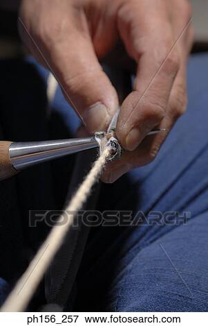 Close-up of a person's hand sewing with a needle View Large Photo Image Stock Photo - Close-up of a person's hand sewing with a needle. Fotosearch