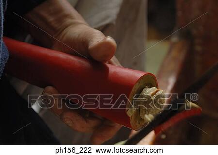 Stock Image - Close-up of a person's hand shaping a candle. Fotosearch