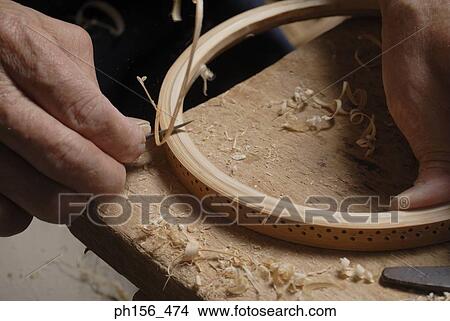 Close-up of a person's hand shaving a wooden circle View Large Photo Image Picture - Close-up of a person's hand shaving a wooden circle. Fotosearch