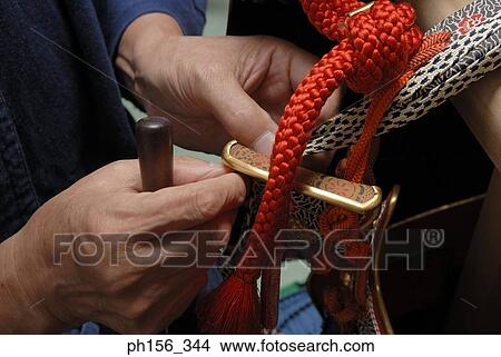 Picture - Close-up of a person's hand tying a rope. Fotosearch
