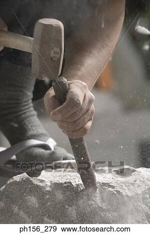 Close-up of a person's hand using a chisel and a hammer on a stone View Large Photo Image Stock Photo - Close-up of a person's hand using a chisel and a hammer on a stone. Fotosearch