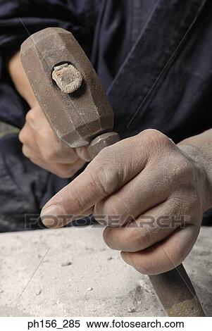 Close-up of a person's hand using a chisel and a hammer on a stone View Large Photo Image Stock Photography - Close-up of a person's hand using a chisel and a hammer on a stone. Fotosearch