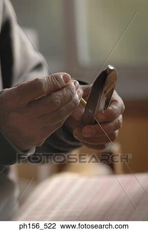 Stock Image - Close-up of a person's hand working on a loom. Fotosearch