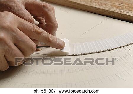 Close-up of a person's hands adjusting paper pieces View Large Photo Image Stock Photo - Close-up of a person's hands adjusting paper pieces. Fotosearch