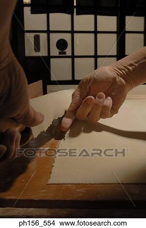 Picture - Close-up of a person's hands breaking rolled dough wrapped on a rolling pin. Fotosearch
