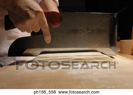 Close-up of a person's hands cutting noodles View Large Photo Image Stock Photo - Close-up of a person's hands cutting noodles. Fotosearch