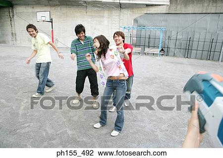 Close-up of a person's hands holding a squirt gun and spraying water on friends View Large Photo Image Stock Image - Close-up of a person's hands holding a squirt gun and spraying water on friends. Fotosearch