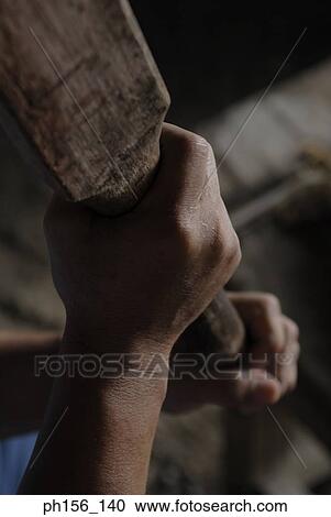 Stock Image - Close-up of a person's hands holding a wooden stick. Fotosearch