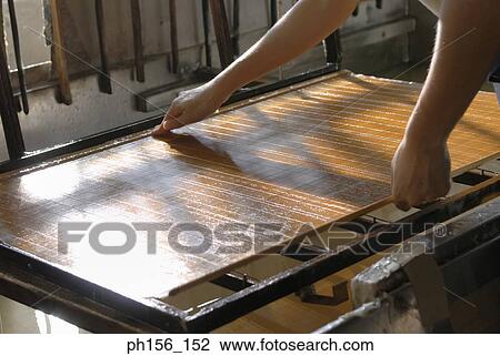 Stock Image - Close-up of a person's hands holding a sheet of wax. Fotosearch
