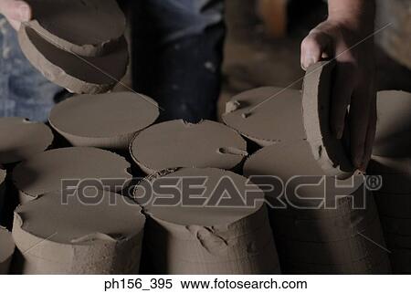 Stock Photography - Close-up of a person's hands holding pieces of clay. Fotosearch
