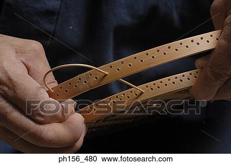 Close-up of a person's hands inserting a bamboo stick into a wooden frame View Large Photo Image Stock Image - Close-up of a person's hands inserting a bamboo stick into a wooden frame. Fotosearch