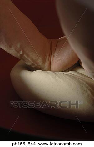 Picture - Close-up of a person's hands kneading dough. Fotosearch