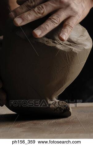 Stock Photo - Close-up of a person's hands kneading mud. Fotosearch