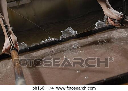 Picture - Close-up of a person's hands making candles in a factory. Fotosearch