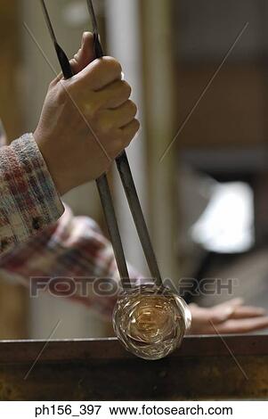 Stock Photo - Close-up of a person's hands molding a glass bulb. Fotosearch