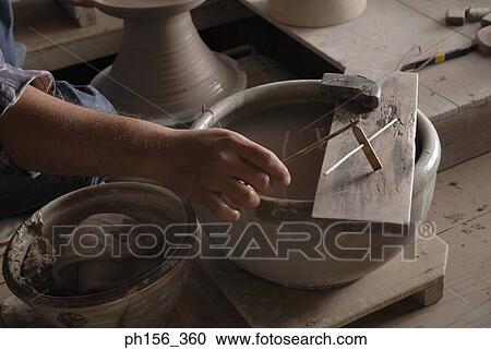 Close-up of a potter's hands holding a hand tool View Large Photo Image Stock Image - Close-up of a potter's hands holding a hand tool. Fotosearch