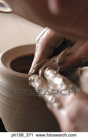 Stock Image - Close-up of a potter's hands making a vase. Fotosearch