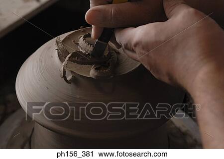 Stock Image - Close-up of a potter's hands making a vase on a pottery wheel. Fotosearch