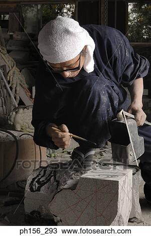 Stock Image - Close-up of a sculptor marking a stone. Fotosearch