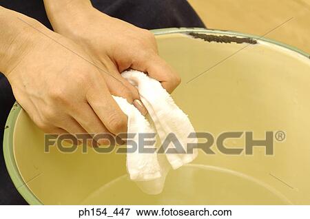 Close-up of a woman's hand squeezing a towel in a bucket View Large Photo Image Stock Photo - Close-up of a woman's hand squeezing a towel in a bucket. Fotosearch