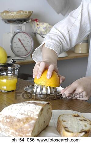 Close-up of a woman's hand squeezing an orange on a juicer View Large Photo Image Stock Photograph - Close-up of a woman's hand squeezing an orange on a juicer. Fotosearch