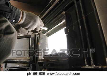 Close-up of a worker's hand closing the door of a furnace View Large Photo Image Stock Photograph - Close-up of a worker's hand closing the door of a furnace. Fotosearch