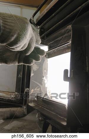 Stock Photography - Close-up of a worker's hand closing the door of a furnace. Fotosearch