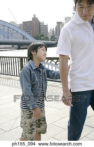 Close-up of a young boy holding his father's hand and smiling View Large Photo Image Picture - Close-up of a young boy holding his father's hand and smiling. Fotosearch