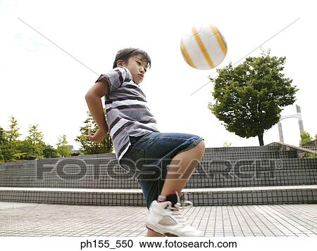 Close-up of a young boy playing football View Large Photo Image Stock Image - Close-up of a young boy playing football. Fotosearch