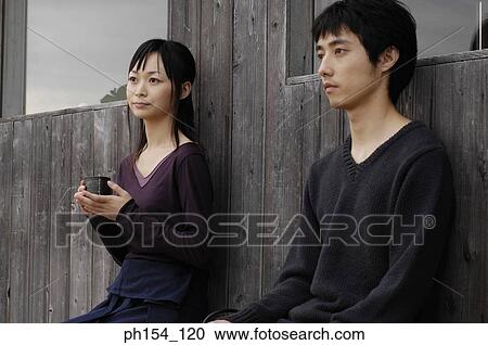 Stock Image - Close-up of a young couple sitting. Fotosearch