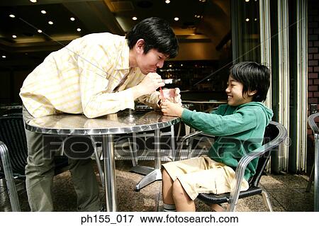 Close-up of a young man and his son in restaurant View Large Photo Image Stock Photo - Close-up of a young man and his son in restaurant. Fotosearch