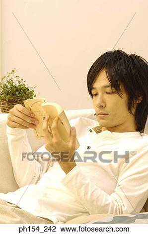 Stock Image - Close-up of a young man reading a book. Fotosearch