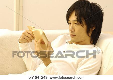 Stock Image - Close-up of a young man reading a book. Fotosearch