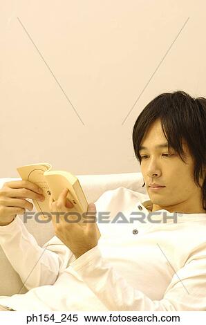 Stock Photography - Close-up of a young man reading a book. Fotosearch