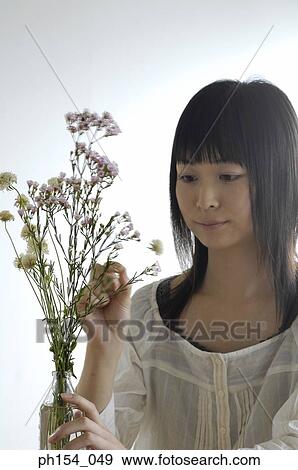 Close-up of a young woman arranging a flower base View Large Photo Image Stock Photo - Close-up of a young woman arranging a flower base. Fotosearch