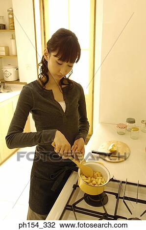 Close-up of a young woman cooking food View Large Photo Image Stock Image - Close-up of a young woman cooking food. Fotosearch
