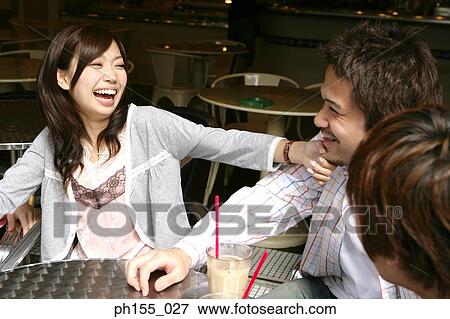 Close-up of a young woman looking at a young man and laughing View Large Photo Image Stock Photo - Close-up of a young woman looking at a young man and laughing. Fotosearch