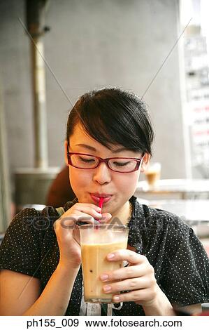 Close-up of a young woman sipping juice View Large Photo Image Stock Photo - Close-up of a young woman sipping juice. Fotosearch