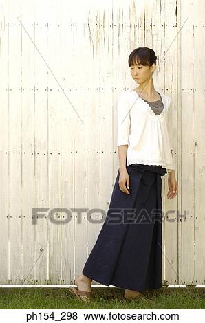 Close-up of a young woman standing View Large Photo Image Stock Photo - Close-up of a young woman standing. Fotosearch