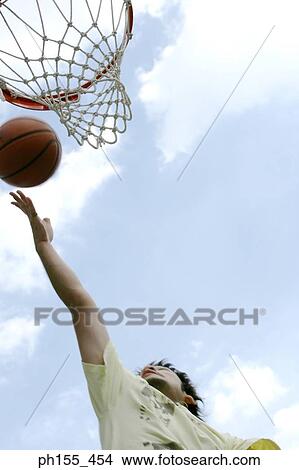 Close-up of basketball player shooting a basket ball into a hoop View Large Photo Image Picture - Close-up of basketball player shooting a basket ball into a hoop. Fotosearch