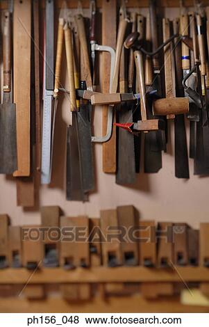 Close-up of work tools hanging on a wall View Large Photo Image Stock Photo - Close-up of work tools hanging on a wall. Fotosearch