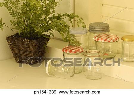Empty jars with a potted plant beside it View Large Photo Image Stock Photo - Empty jars with a potted plant beside it. Fotosearch