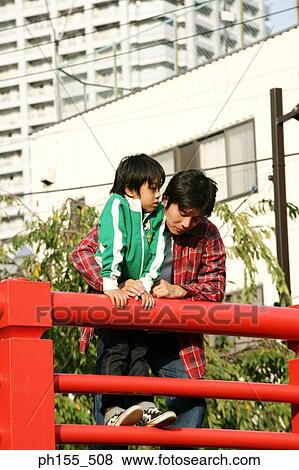 Father and his son leaning on a railing and looking down View Large Photo Image Stock Photo - Father and his son leaning on a railing and looking down. Fotosearch