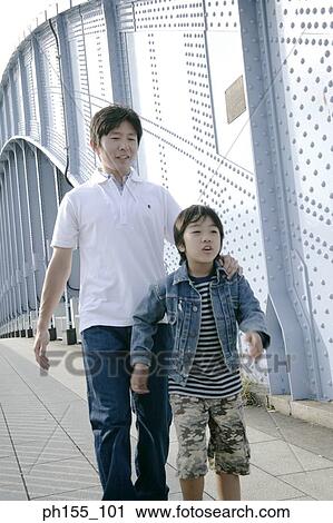 Father and his son walking on a bridge View Large Photo Image Stock Image - Father and his son walking on a bridge. Fotosearch
