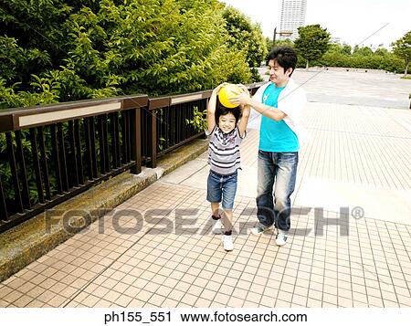 Father holding a ball over his son's head View Large Photo Image Stock Image - Father holding a ball over his son's head. Fotosearch