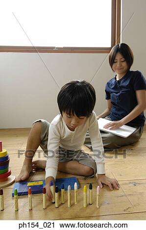 Girl playing with felt tip pens with her mother sitting behind her View Large Photo Image Stock Image - Girl playing with felt tip pens with her mother sitting behind her. Fotosearch