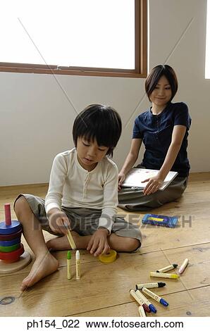 Girl playing with felt tip pens with her mother sitting behind her View Large Photo Image Stock Image - Girl playing with felt tip pens with her mother sitting behind her. Fotosearch